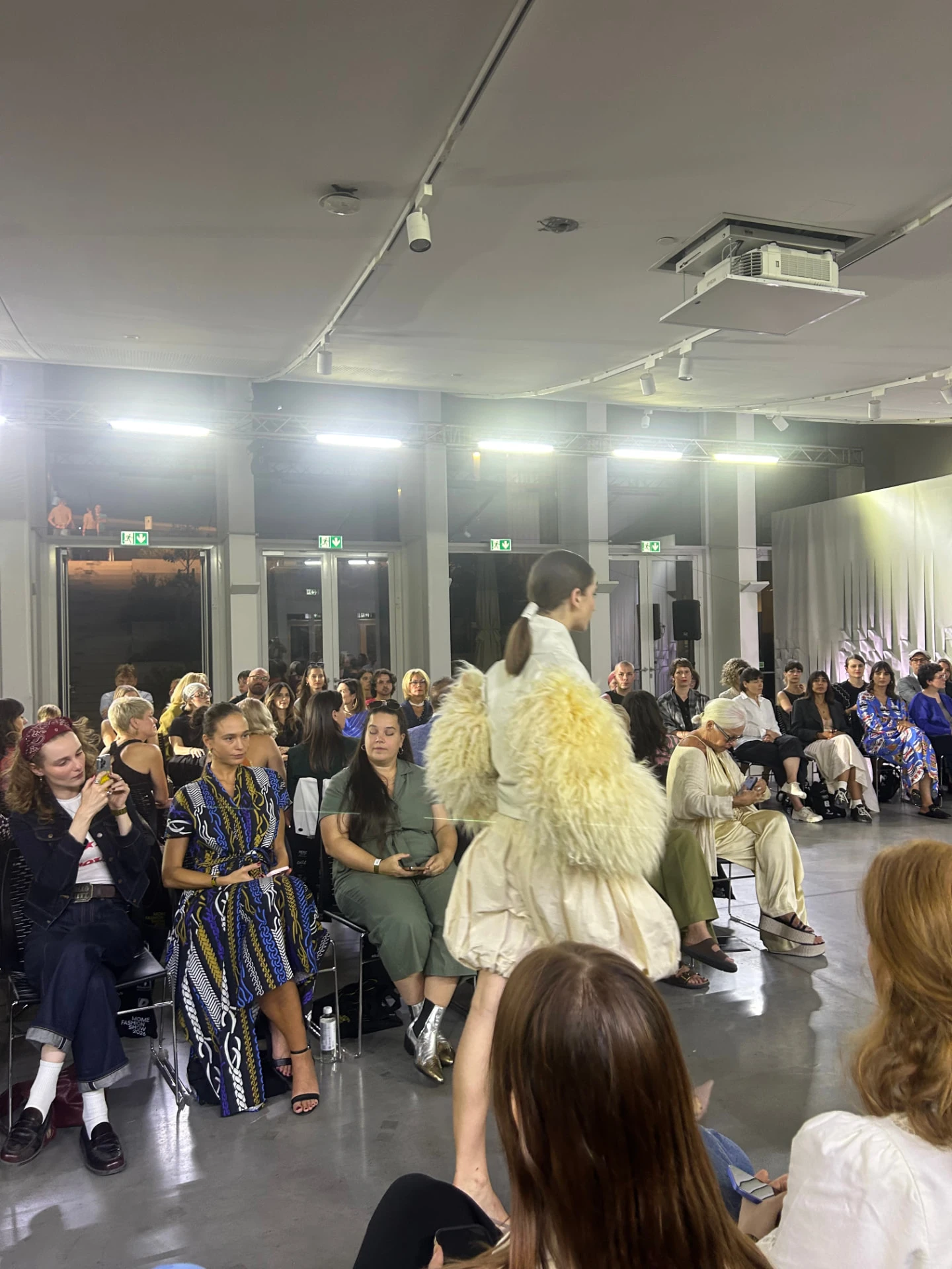 Egy modell a MOME Fashion Show 2026 kifutóján a közönség sorai között