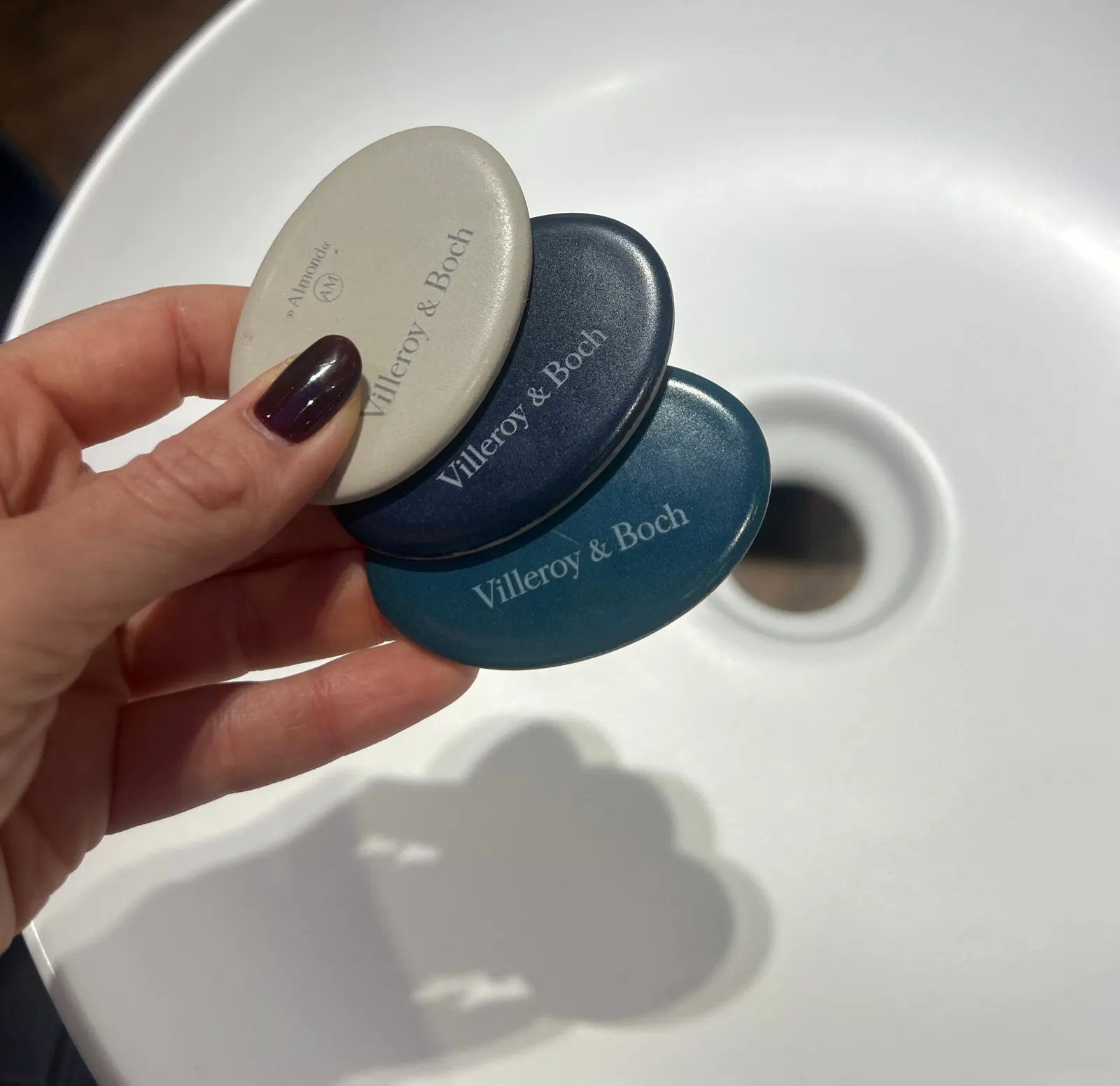 Villeroy & Boch színminták egy kézben, mosdókagyló felett